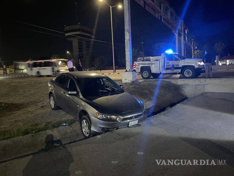 $!El auto terminó incrustado en el canal de desagüe.