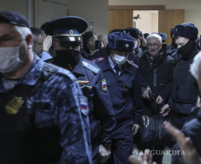 $!La policía escolta a Oleg Orlov después de que se anunciara su veredicto en la audiencia judicial en el Tribunal de Distrito de Golovinsky en Moscú, Rusia.