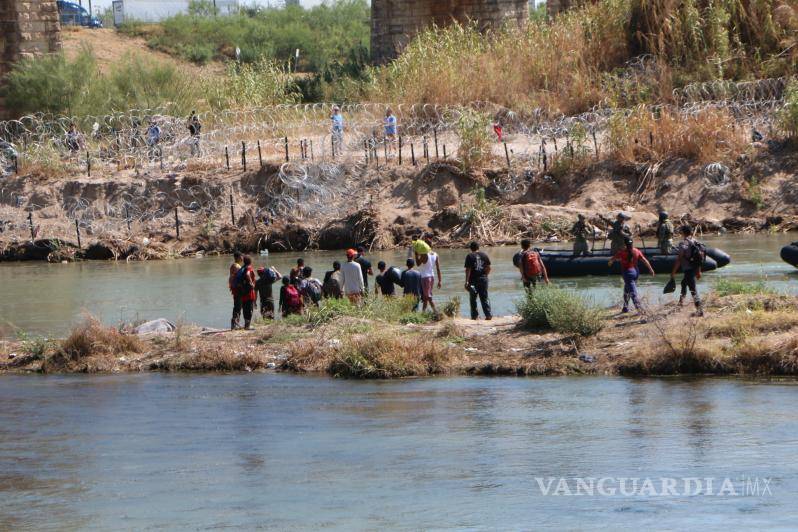 $!Un grupo de migrantes es observado por elementos de la Guardia Nacional de Texas cuando cruzan el río Bravo.