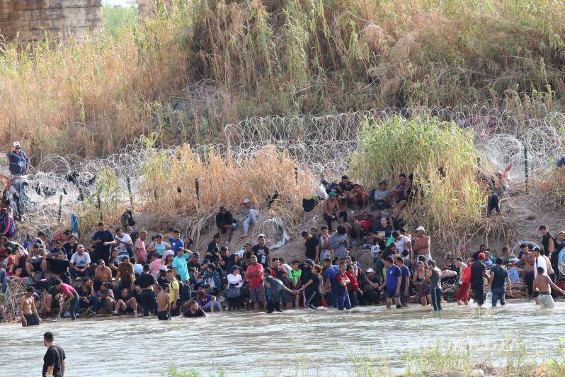 $!Cientos de migrantes esperan a orillas del rio Bravo a que les permitan cruzar las alambradas.
