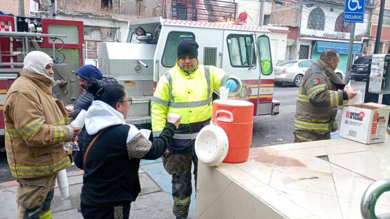 $!Miembros del cuerpo de bomberos de Saltillo Poniente comparten un momento de solidaridad con los ciudadanos, brindando apoyo en un día frío y desafiante para la comunidad.