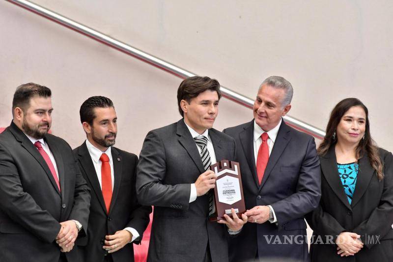 $!El hijo de Laura Reyes Retana Ramos, Diego Armendáriz, recibe un reconocimiento especial en honor a la labor social y trayectoria política de su madre durante la sesión solemne.