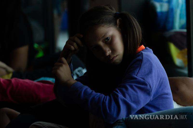 $!Niña hondureña peina su cabello mientras su madre descansa, ambas fueron retenidas en la Central de Autobuses de Saltillo.