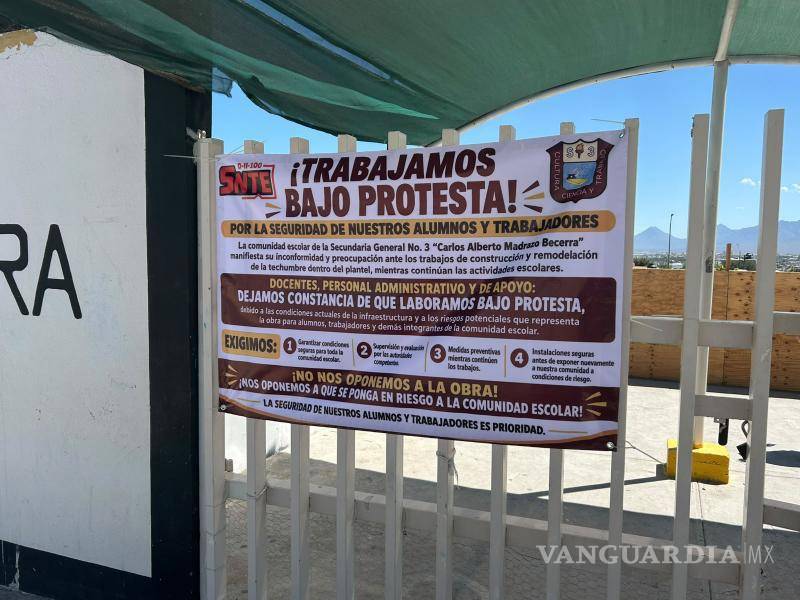$!Personal de la secundaria colocó una lona en la que manifestó que labora bajo protesta y exigió condiciones seguras mientras continúan las obras.