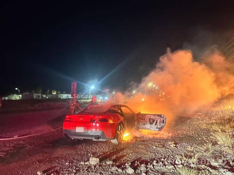 $!Los bomberos combatieron el incendio que envolvía el Chevrolet Camaro en la calzada Antonio Narro.