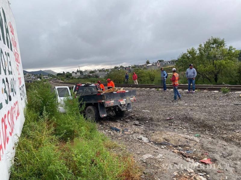 $!La camioneta Chevrolet de la empresa SICMA quedó fuera del camino tras derrapar y ser arrastrada por el tren.