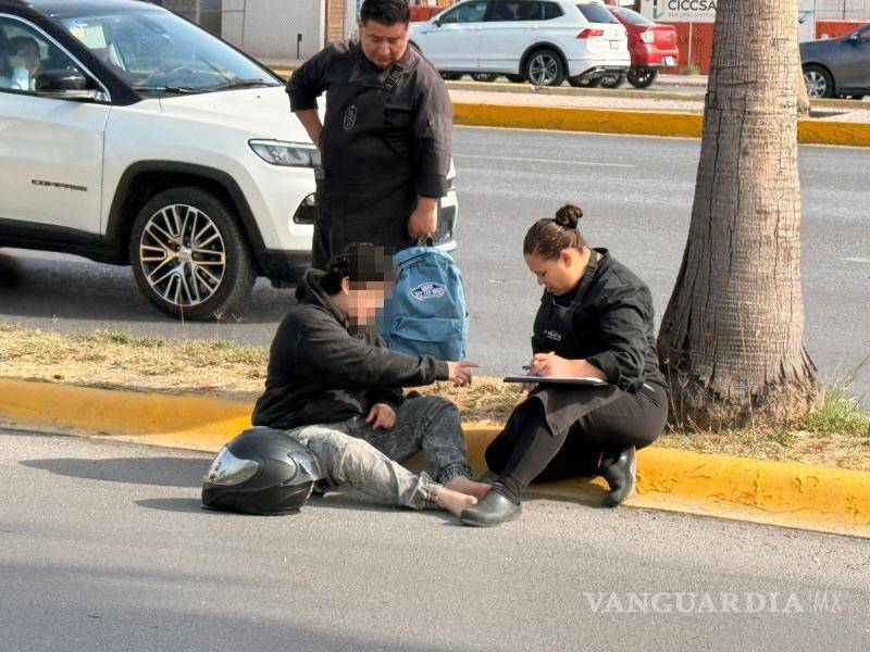 $!Oficiales de Tránsito Municipal auxiliaron a la joven motociclista luego de la caída.
