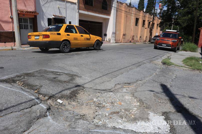 $!Automovilistas intentan evitar los daños en la vialidad, lo que pone en riesgo los vehículos estacionados a los lados.