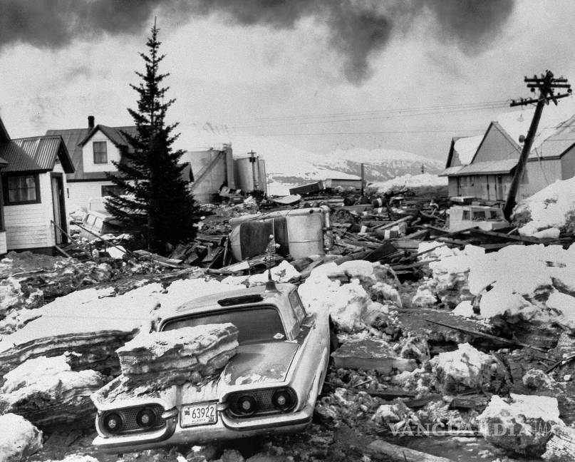 $!Autos enterrados dañados por enormes bloques de hielo empujados a la orilla por el tsunami luego del gran terremoto en Valdez, Alaska, que golpeó con fuerza letal el 29 de marzo de 1964.