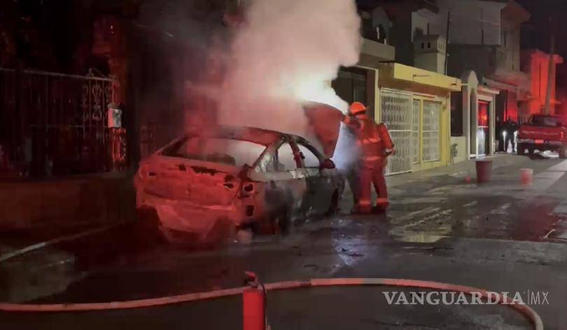 $!Policía y vecinos lucharon por apagar las llamas devoradoras que consumieron por completo el automóvil, sin poder evitar la destrucción total.