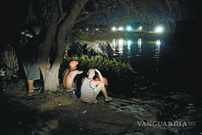 $!Incluso de noche, los migrantes no pierden de vista el otro lado del río, mientras son vigilados por la patrulla fronteriza.