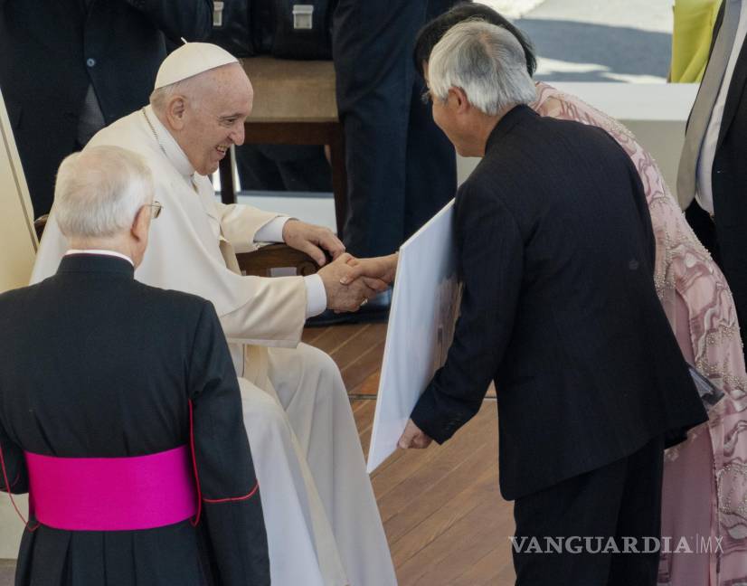 $!El fotógrafo ganador del premio Pulitzer, Nick Ut (c) y la embajador ade la UNESCO, Kim Phuc (d) le muestran al Papa Francisco la foto ganadora del Pulitzer de 1973.