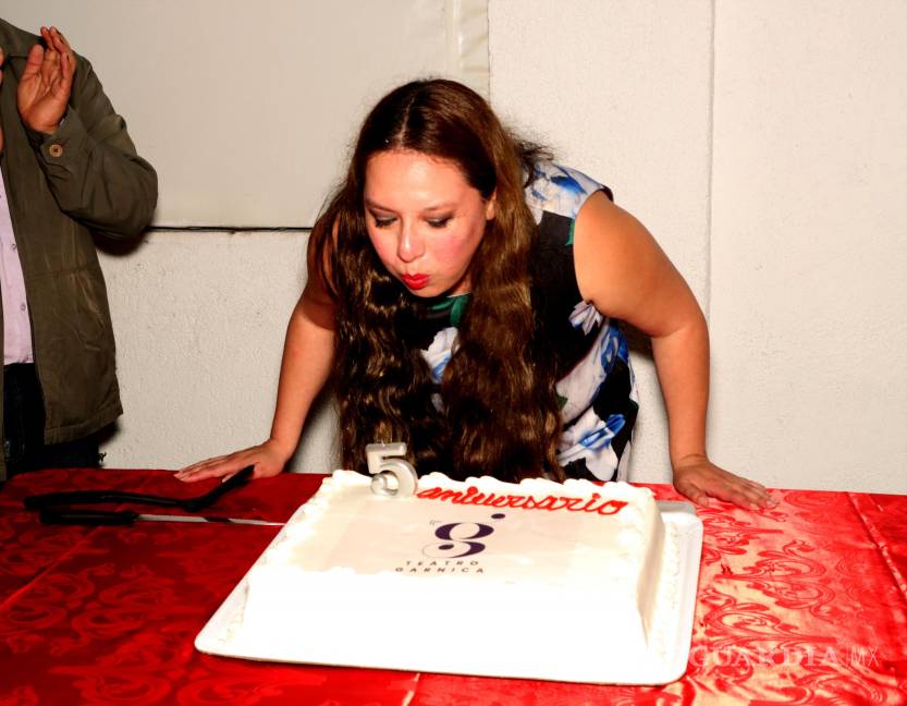 $!Gina Garnica soplando las velitas del pastel de aniversario.