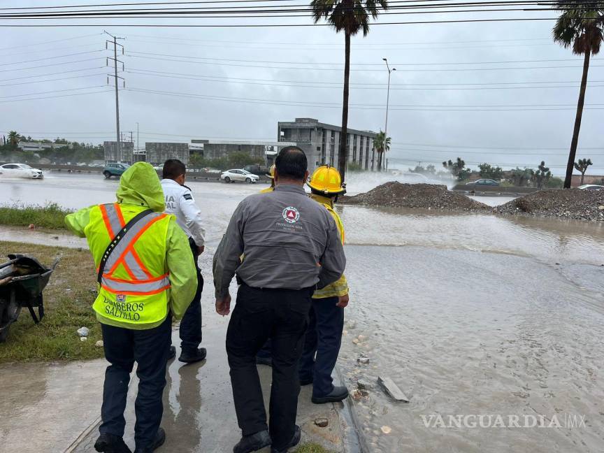 $!Elementos de PC y bomberos auxilian a conductores cuyos vehículos quedaron varados en las vialidades afectadas por las lluvias en Saltillo.