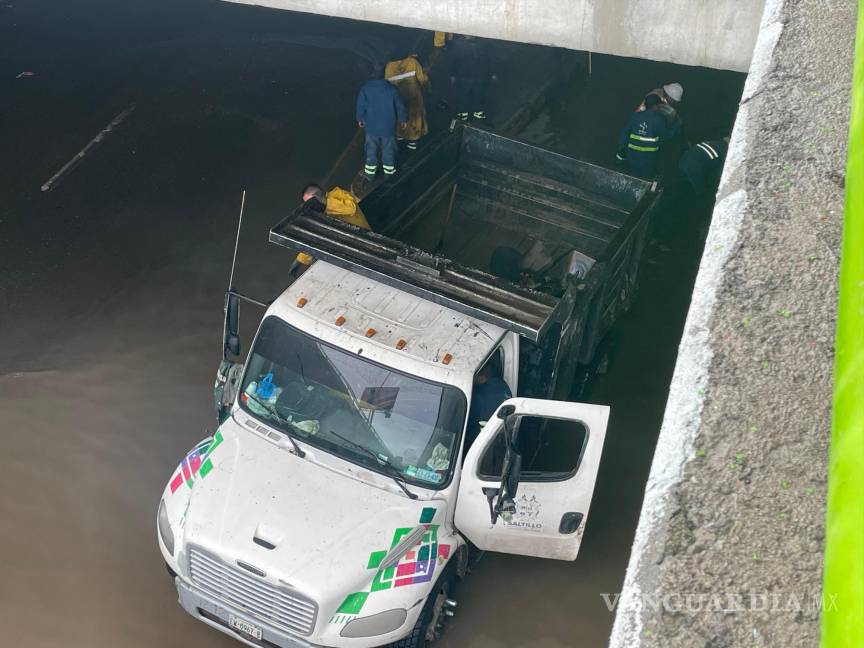 $!Equipos de mantenimiento del municipio intervinieron en el paso a desnivel inundado para despejar las rejillas pluviales bloqueadas.