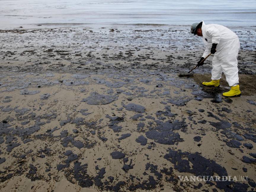 $!A worker removes oil at California's Refugio State Beach on May 21, 2015.
