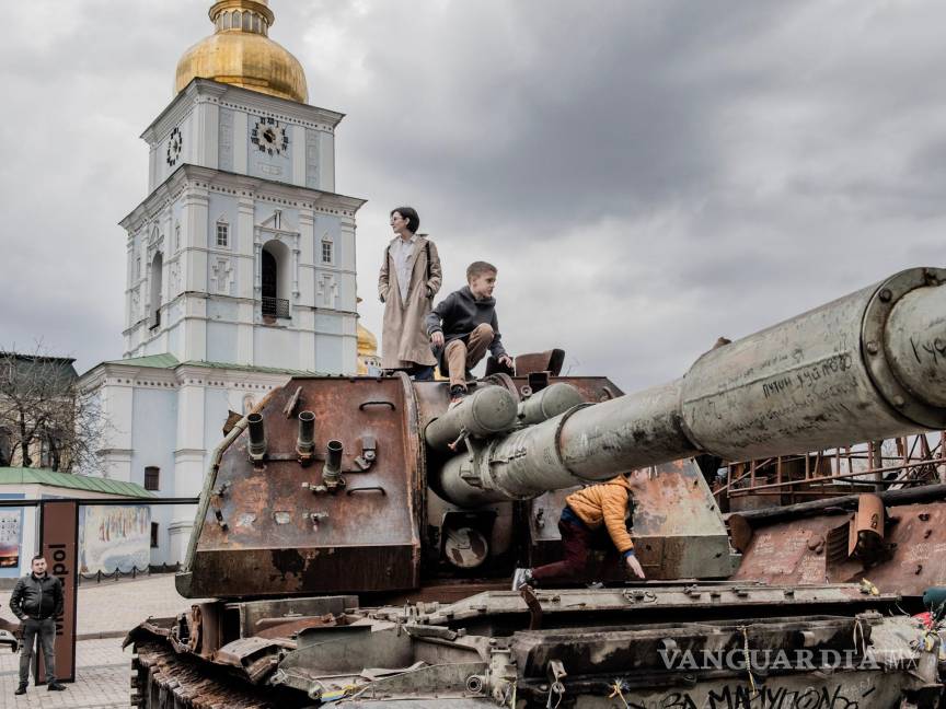 $!La gente se sube al casco de un tanque ruso destruido en la plaza Mykhailivska, en las afueras del Monasterio de las Cúpulas Doradas de San Miguel en Kiev.
