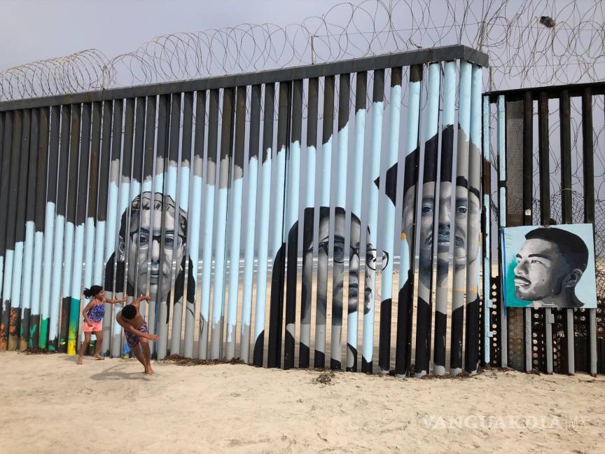 $!Niños juegan frente a un mural de la artista Lizbeth De La Cruz Santana, en el lado mexicano del muro fronterizo en Tijuana, México, el 9 de agosto de 2019.