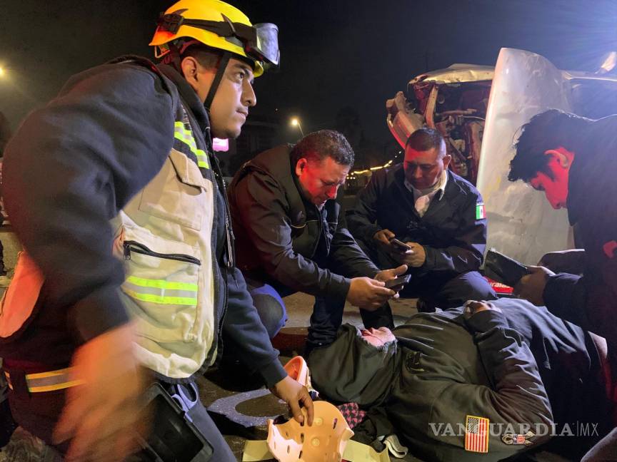 $!Paramédicos y automovilistas auxilian al conductor tras el aparatoso accidente en el bulevar Fundadores, donde el vehículo volcó tras impactarse con los muros de concreto.