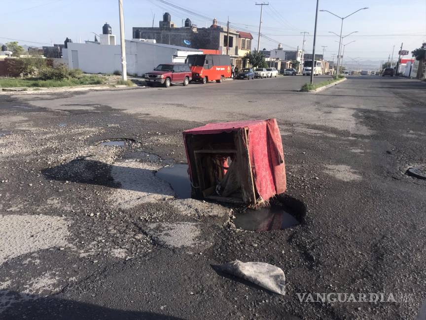 $!En redes sociales se han hecho reportes sobre baches, que son señalados con objetos para evitar caer.