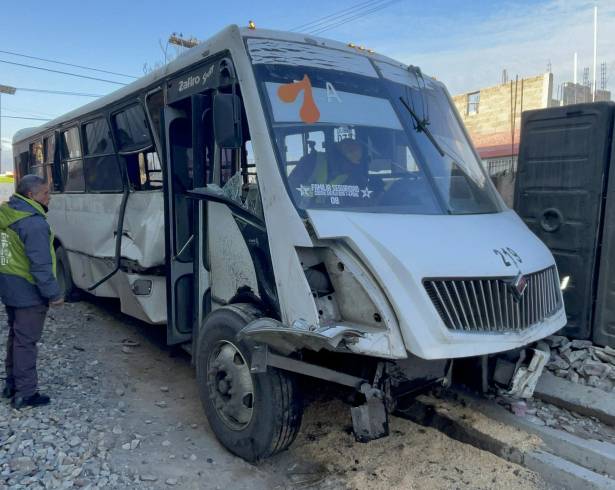 La combi de la ruta 7A quedó a un costado de las vías tras ser embestida por el tren.
