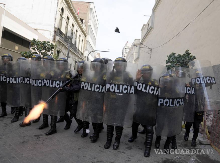 $!Un policía con equipamiento antimotines dispara su escopeta para dispersar a los manifestantes opositores que protestan contra la presidenta peruana.