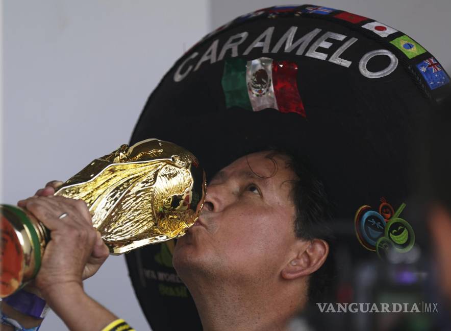 $!Héctor Chávez, hincha de la selección de México conocido como Caramelo besa una réplica de la Copa Mundial en Iztapalapa, Ciudad de México.