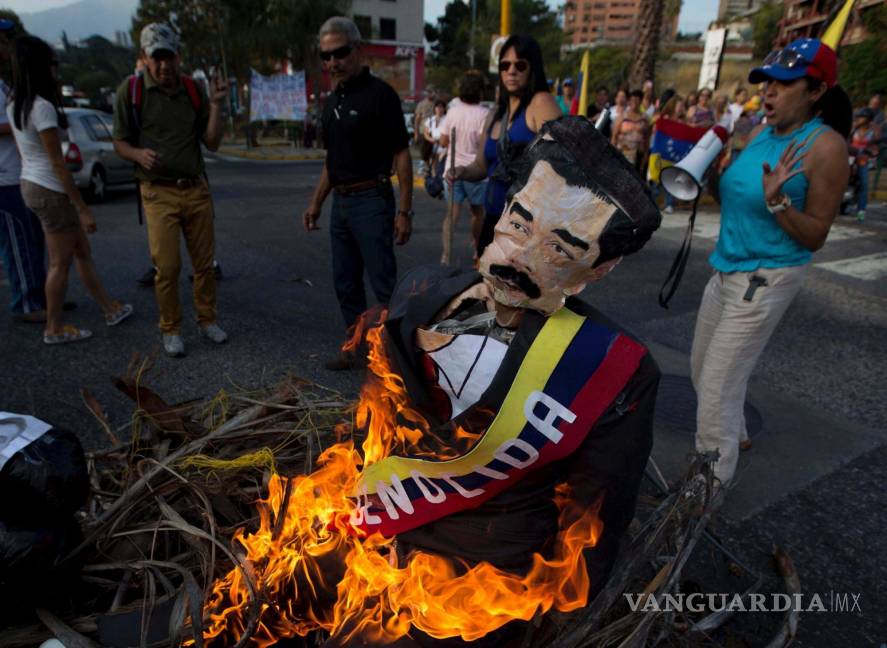 $!Ciudadanos opositores queman una figura con la imagen del presidente de Venezuela, Nicolás Maduro, en Caracas, Venezuela, el 20 de abril de 2014.