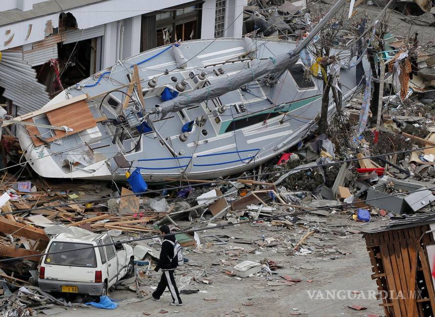 $!Un hombre camina cerca de un yate varado en la zona afectada por el tsunami en Ofunato, Prefectura de Iwate, Japón, el 15 de marzo de 2011, cuatro días después del desastre.