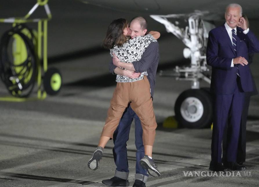 $!Evan Gershkovich abraza a su madre, Ella Milman, mientras el presidente Joe Biden, a la derecha, observa en la Base de la Fuerza Aérea Andrews, Maryland.