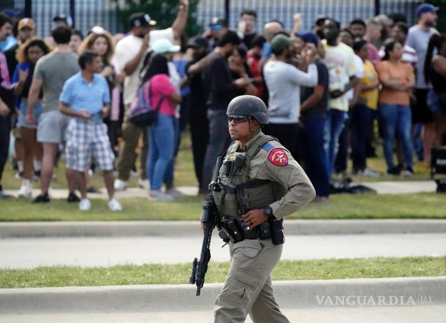 $!Un oficial de la ley camina mientras las personas son evacuadas de un centro comercial donde ocurrió un tiroteo masivo en Allen, Texas.