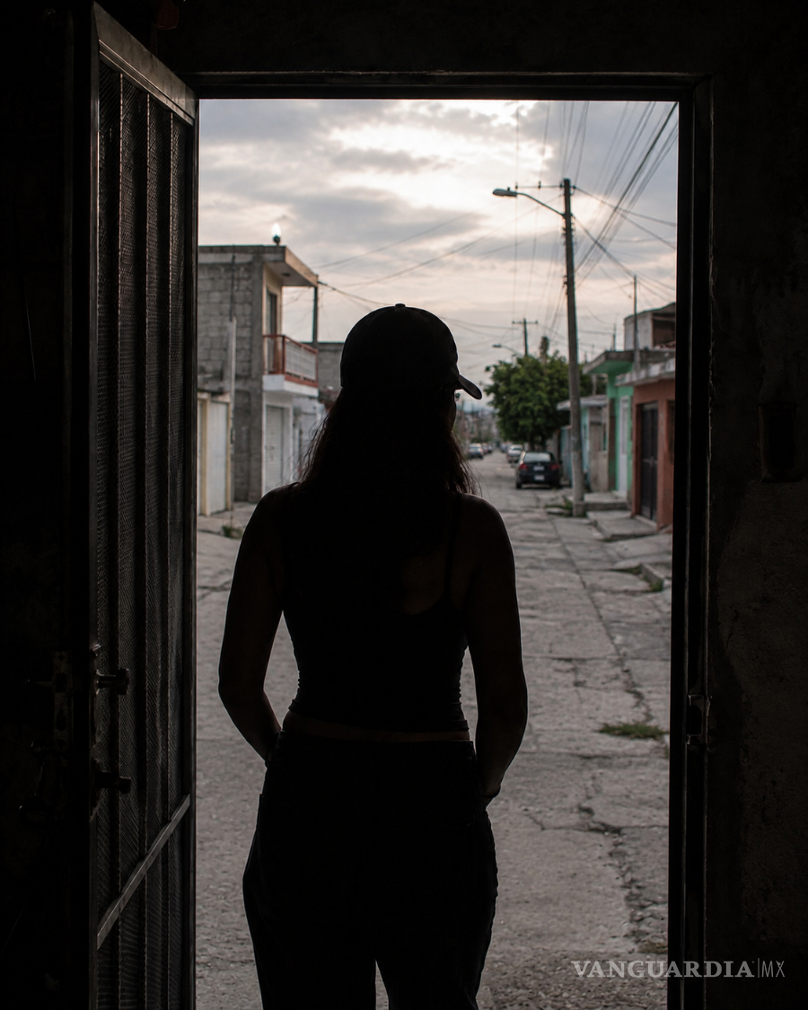 $!Desde el umbral de su vivienda, la mujer observa la calle donde continúa desarrollándose su vida cotidiana. La puerta separa el espacio en el que puede narrar lo ocurrido de un exterior que forma parte del mismo conflicto.