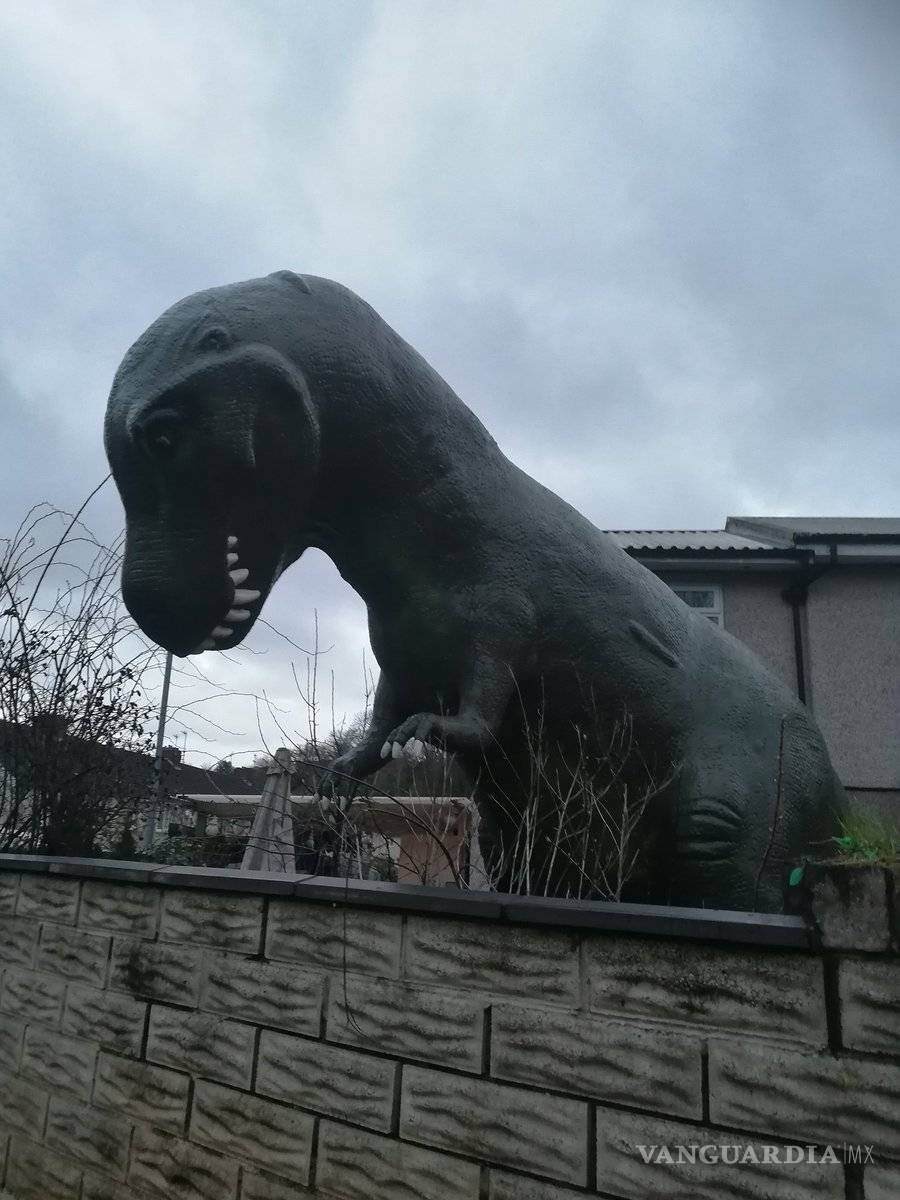 $!Compró un dinosaurio de plástico gigante y su casa se convirtió en atracción turística