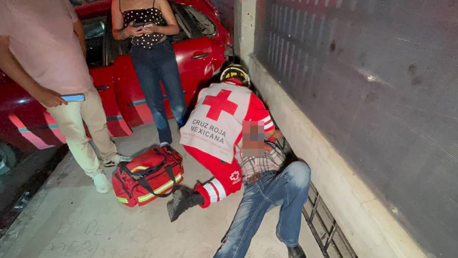 El conductor terminó parcialmente prensado contra una barda cuando intentó detener su propio vehículo después de que tomó impulso.