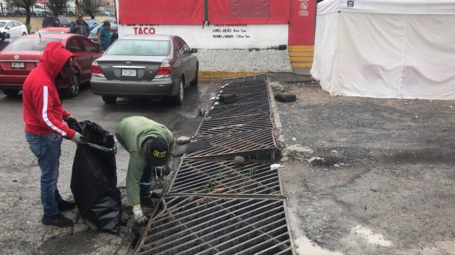 Personal retira basura, hojas y tierra que pueden obstruir las rejillas durante las lluvias.