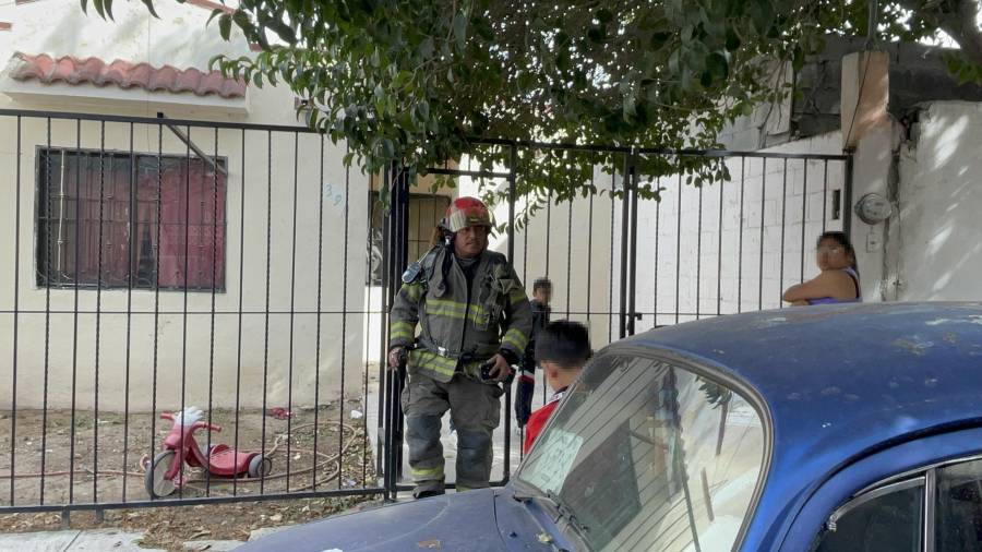 Elementos del Cuerpo de Bomberos inspeccionan el área de la cocina donde se originó el conato de incendio.