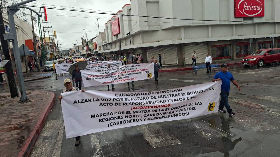 Ex trabajadores de AHMSA recorren calles de Monclova con lonas para exigir solución al conflicto laboral.