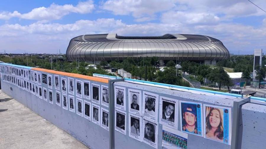 Familiares de víctimas de desaparición colocaron cárteles con los rostros de sus seres queridos en el puente peatonal ubicado frente al Estadio Monterrey, donde se jugarán los partidos del Mundial en Nuevo León.