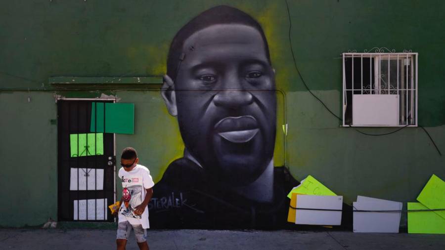 Benjamin Jackson III, de 10 años, pasa junto a un mural que representa a George Floyd en el barrio Watts de Los Ángeles, el martes 9 de junio de 2020. AP/Jae C. Hong