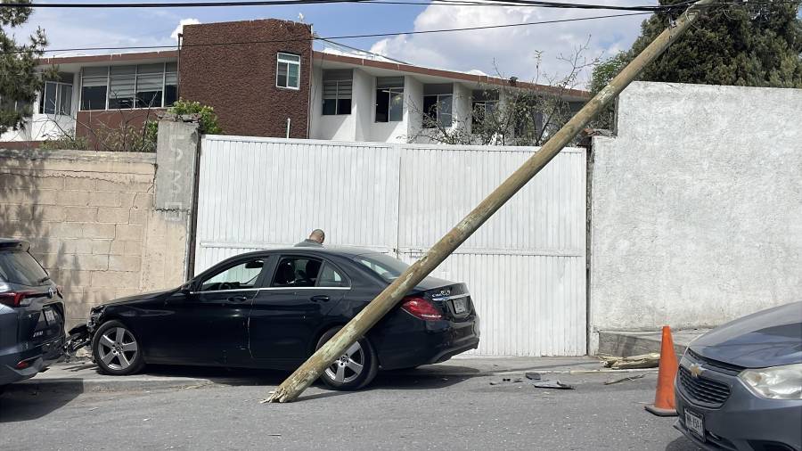El conductor de 68 años perdió el conocimiento al manejar, provocando daños materiales en un poste y la barda del colegio.