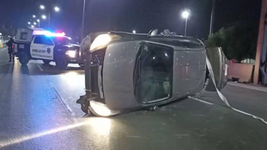El Nissan Versa terminó volcado sobre uno de sus costados tras impactarse contra el muro.