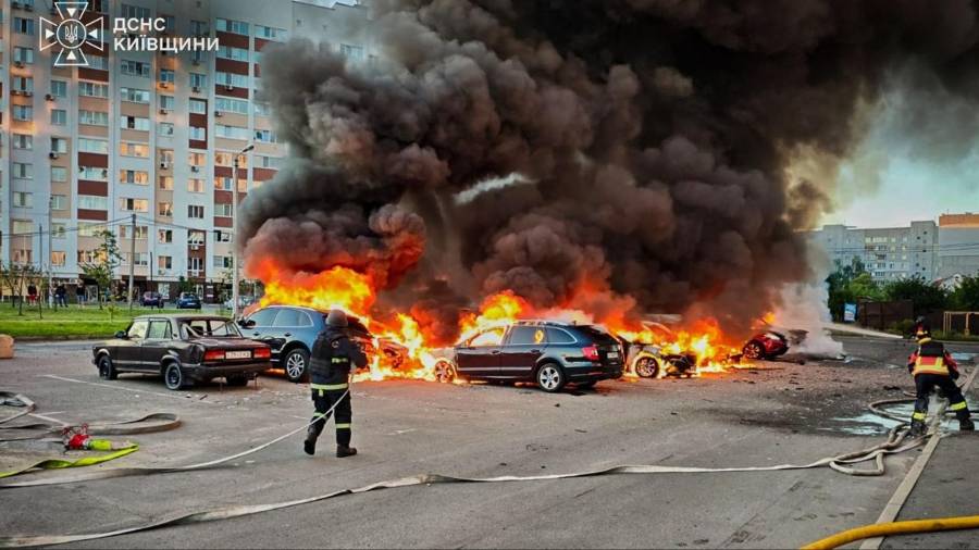 En esta imagen, proporcionada por el Servicio Ucraniano de Emergencias, bomberos intentan sofocar las llamas en unos autos tras un ataque con drones rusos en la región de Kiev, Ucrania.