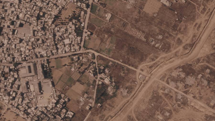 Un tramo de una barrera de tierra construida por el ejército israelí, desde el lado derecho y hacia abajo, en el centro de la Franja de Gaza. A la izquierda, el campo de refugiados de Maghazi, y al otro lado casas demolidas.