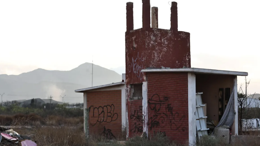 La estructura de la antigua escuela permanece abandonada mientras, a la distancia, se observa humo en el sector donde vecinos han denunciado reiteradamente la quema de llantas.