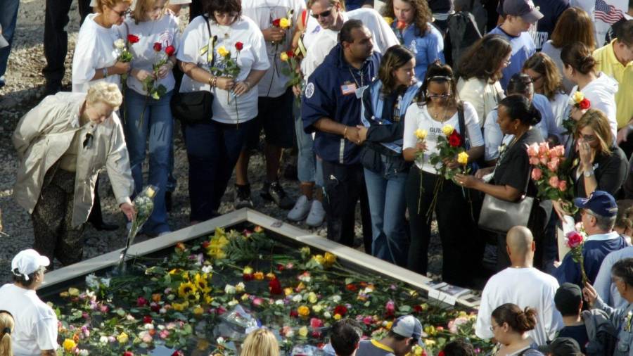 Familiares de las víctimas de los atentados contra el World Trade Center depositan flores en uno de los dos estanques que reproducen la huella de las dos torres del World Trade Center en la Zona Cero en Nueva York.
