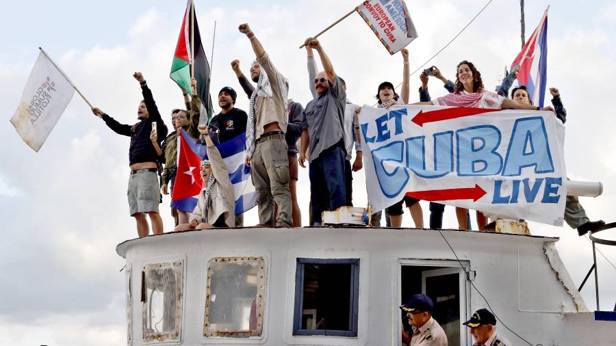 Integrantes del Convoy Nuestra América saludan a su llegada con ayuda humanitaria al puerto en La Habana.