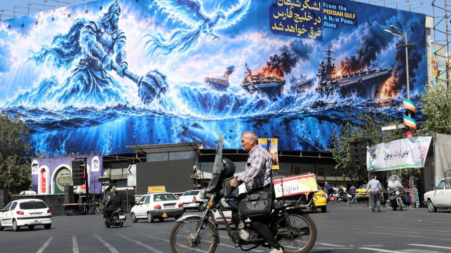 Un iraní conduce junto a una valla publicitaria antiamericana con una frase en persa que dice: “El ejército del diablo se ahogará en el golfo Pérsico”, en la plaza Enghelab de Teherán, Irán, el 21 de septiembre de 2026.