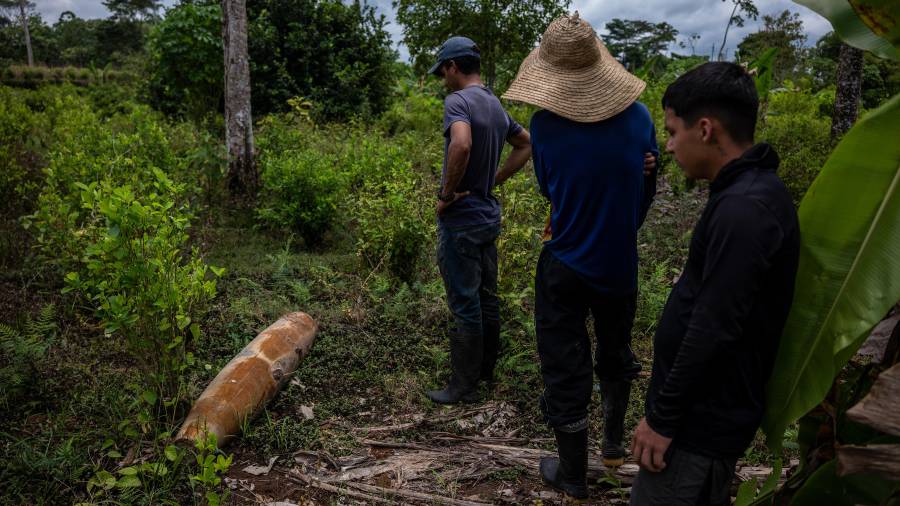 Unos hombres inspeccionan los restos de una bomba sin explotar de 227 kilogramos que cayó en una finca de la región de Putumayo, en el sur de Colombia.