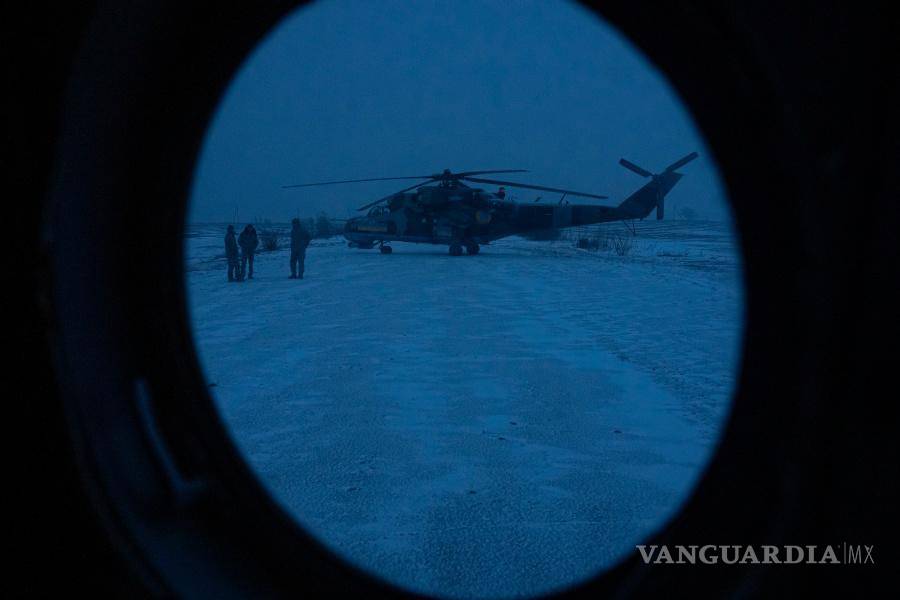 $!Los miembros de la tripulación de tierra de la 18.ª Brigada Sikorsky reabastecen un helicóptero de combate con cohetes antes de una misión en el este de Ucrania.