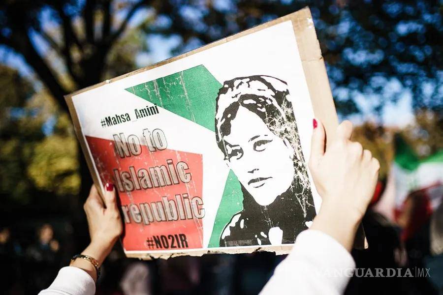 $!Una mujer muestra una imagen de la iraní Mahsa Amini en una concentración.